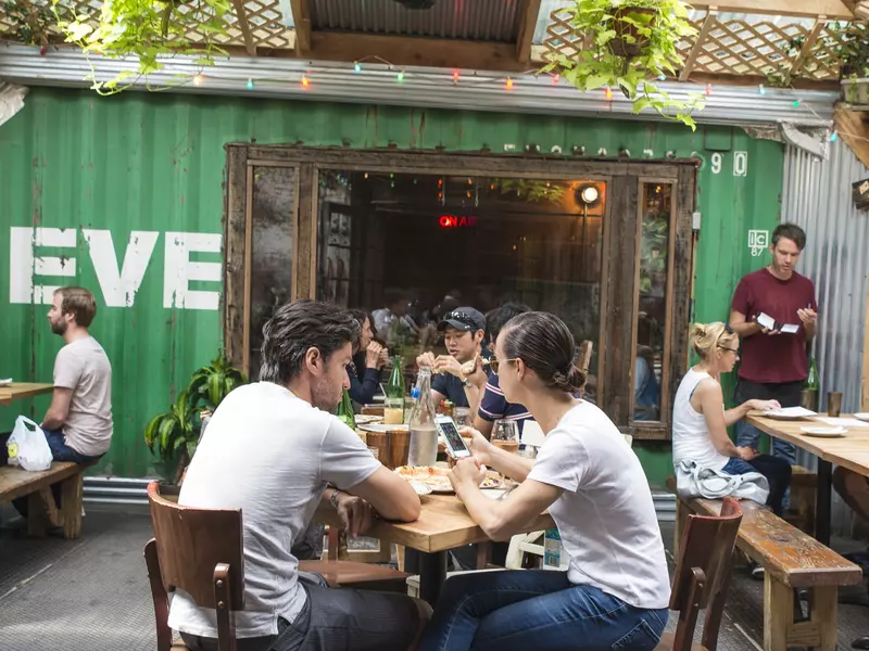 Patrons eat in the pizzeria’s garden at Roberta's Pizza