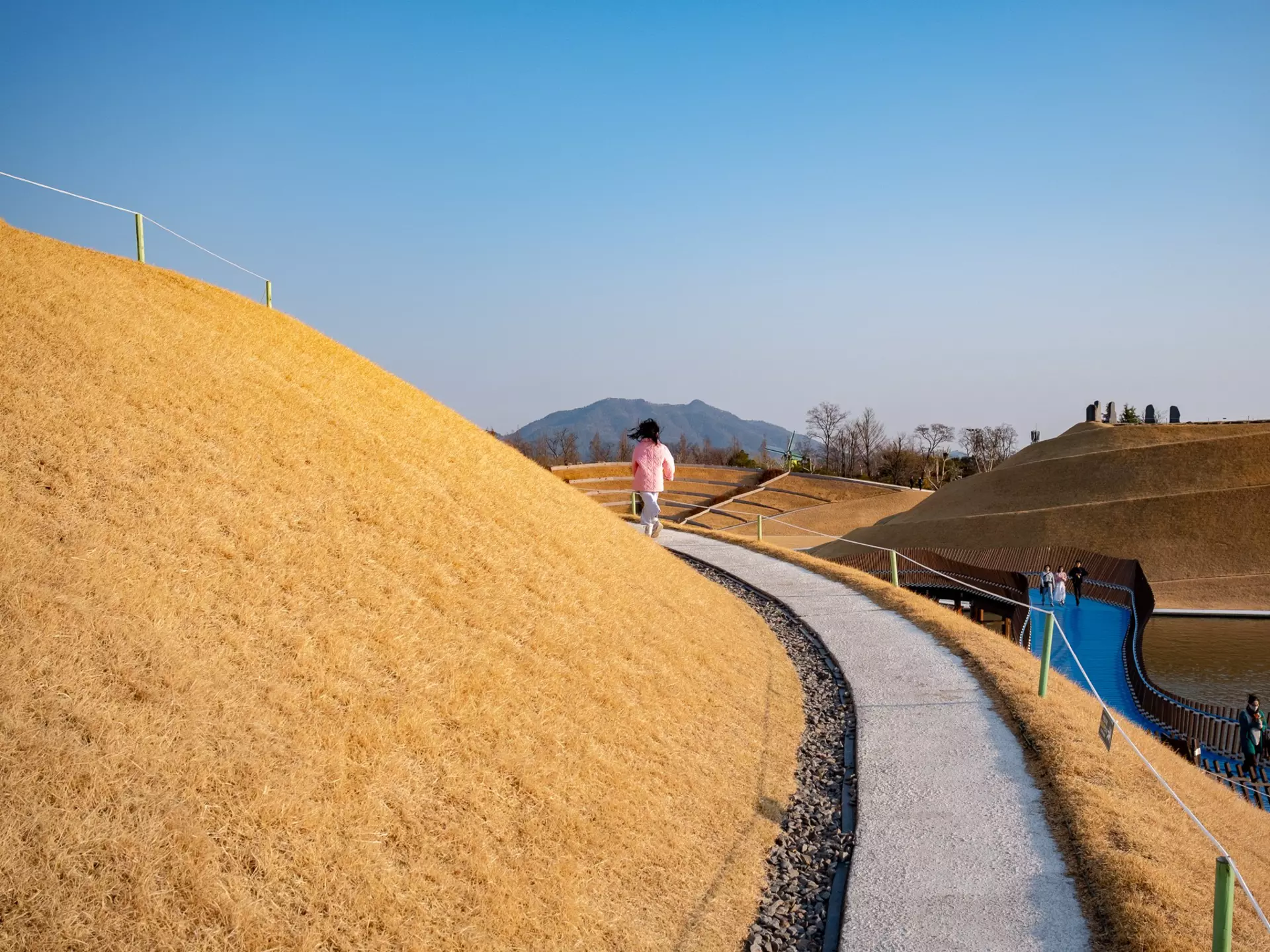 A young girl runs along a pathway in Suncheon Bay National Garden, South Korea.