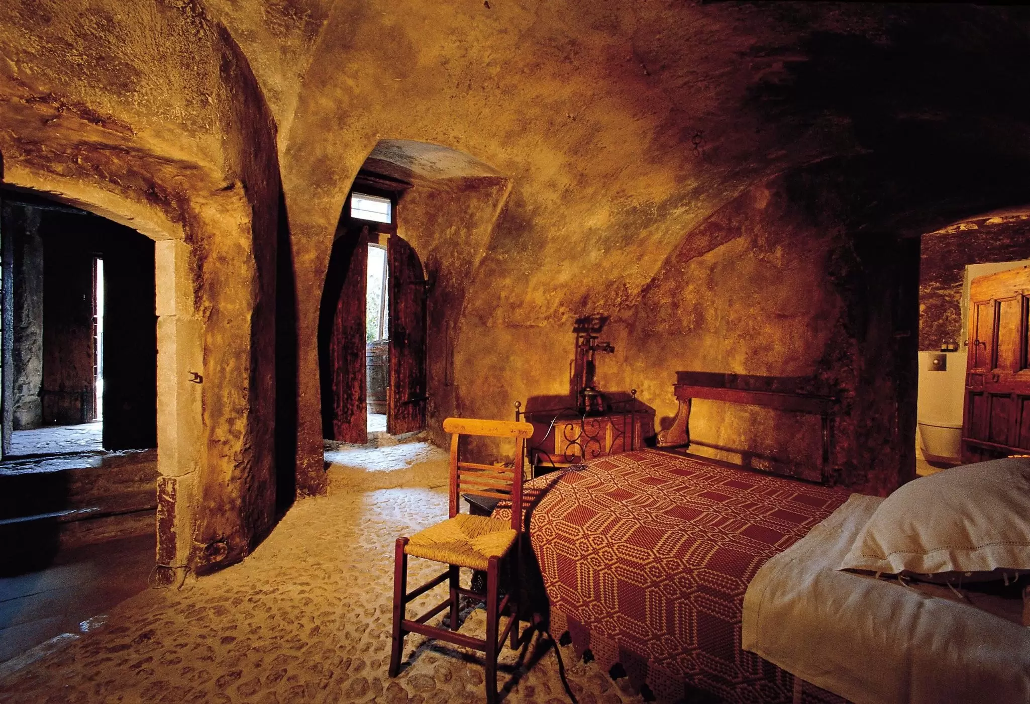 A minimalist bedroom in a boutique hotel with original features of the ancient building: Sextantio Albergo Diffuso, Italy