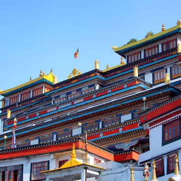 A colorful Tibetan Buddhist monastery in Darjeeling, India viewed from the ground looking up