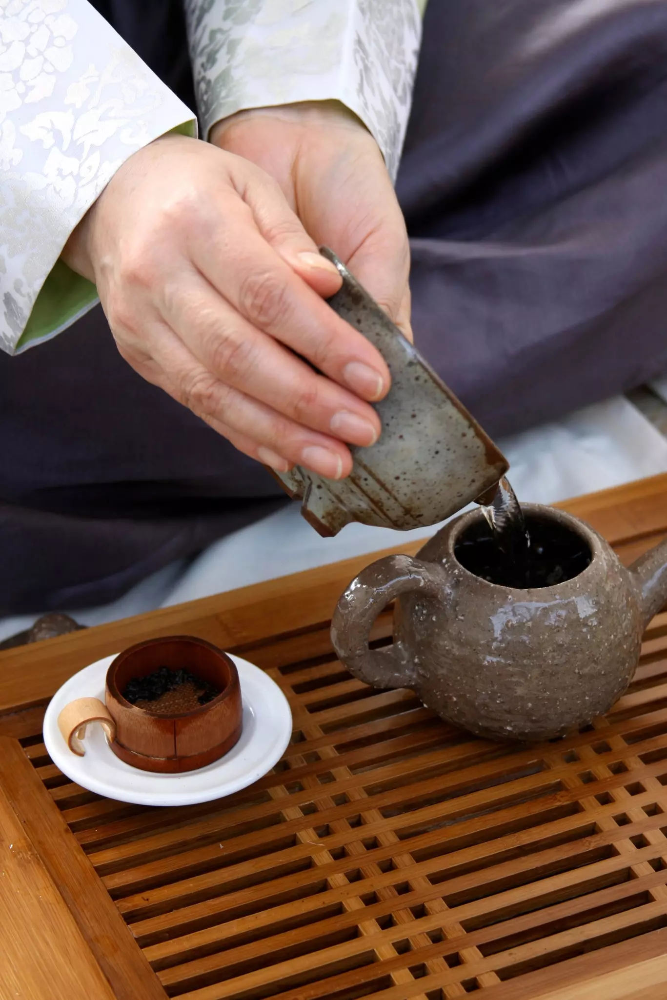 Pouring water into a teapot during a traditional Korean tea ceremony.
