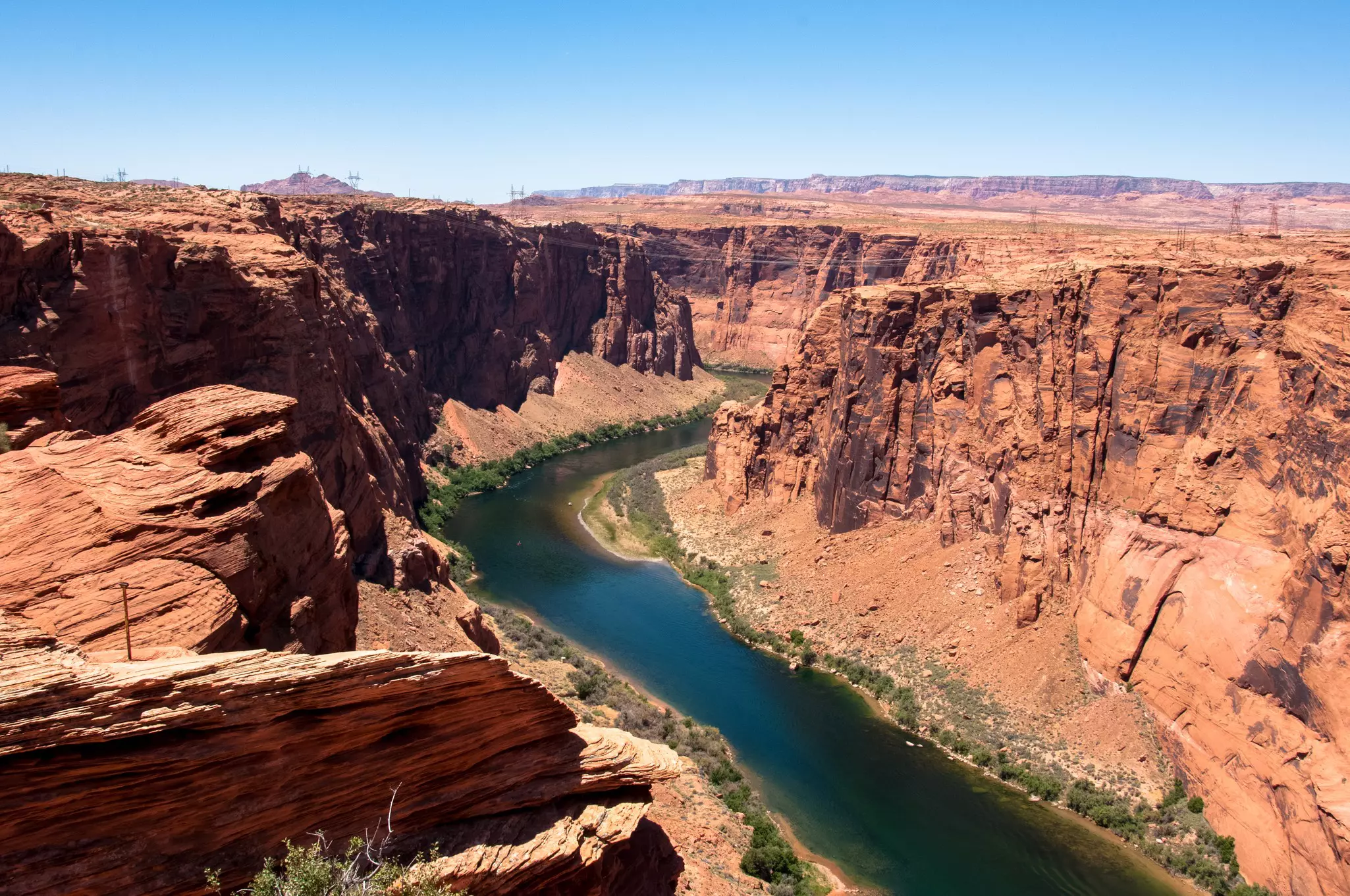 River in a canyon surrounded by red rocky mountains on a sunny day.