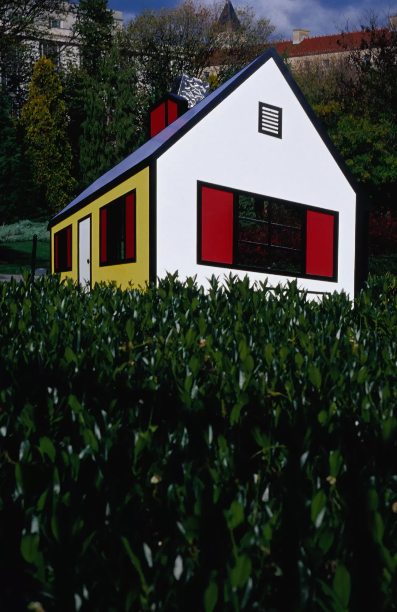 An artwork called House I by Roy Lichtenstein sits in the Sculpture Garden of the National Gallery of Art in Washington. Its brightly-colored sides in red and yellow stand out against the greenery of the gardens itself.