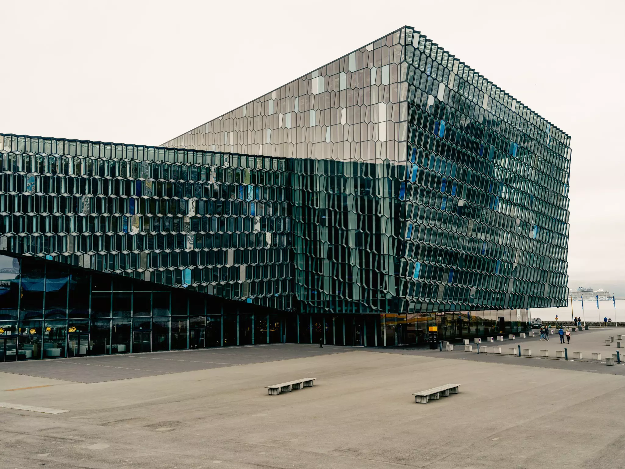 A large glass building with benches nearby