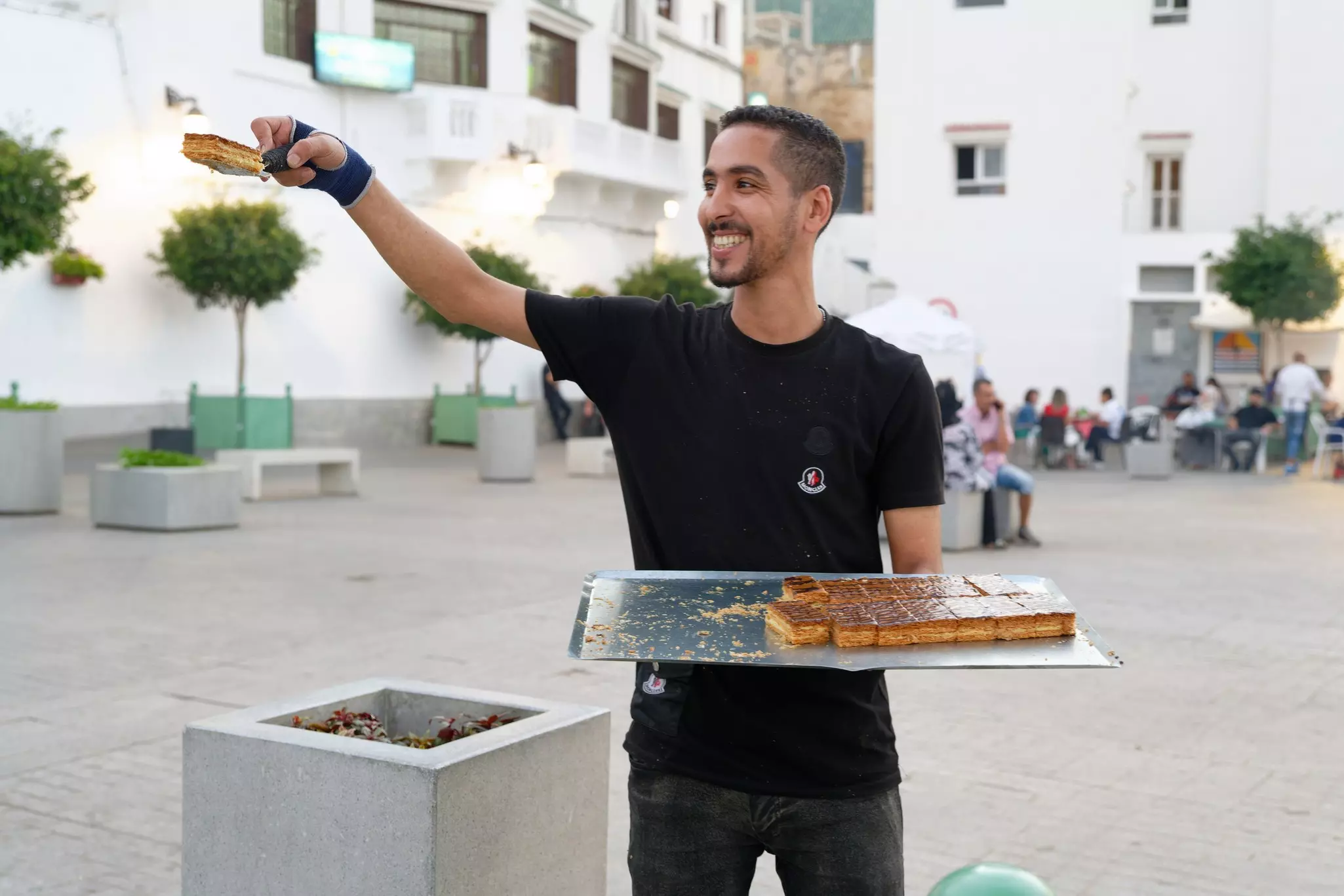 A waiter holding a tray of  mille-feuille cakes.