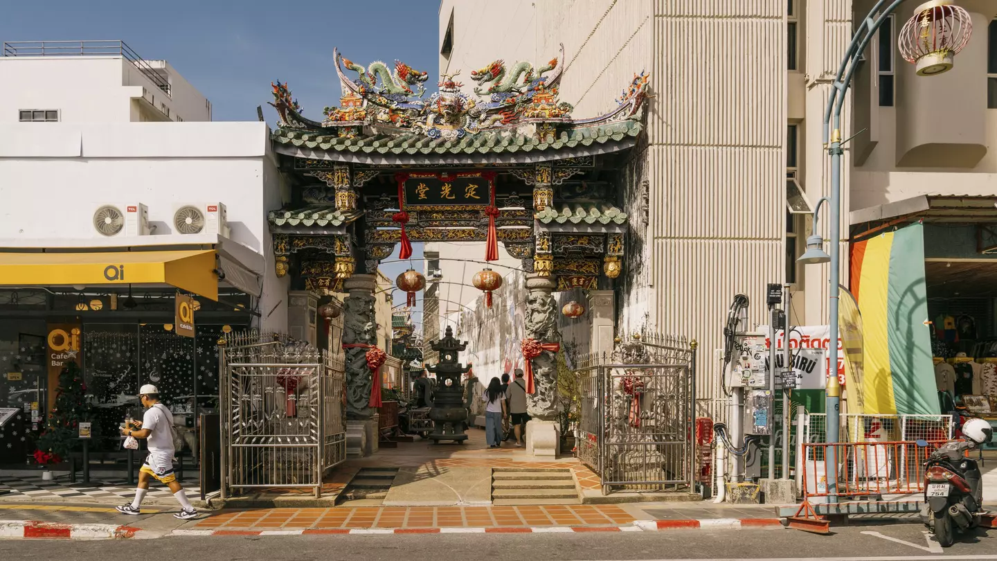 A green-roofted shrine between two buildings