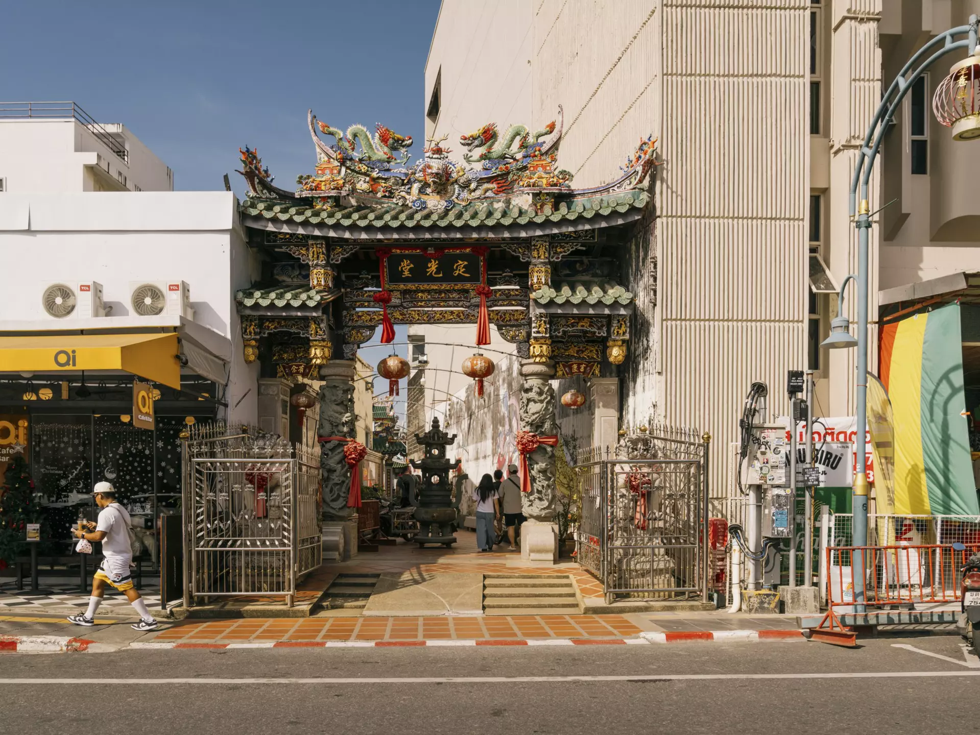 A green-roofted shrine between two buildings