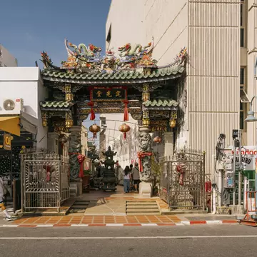 A green-roofted shrine between two buildings