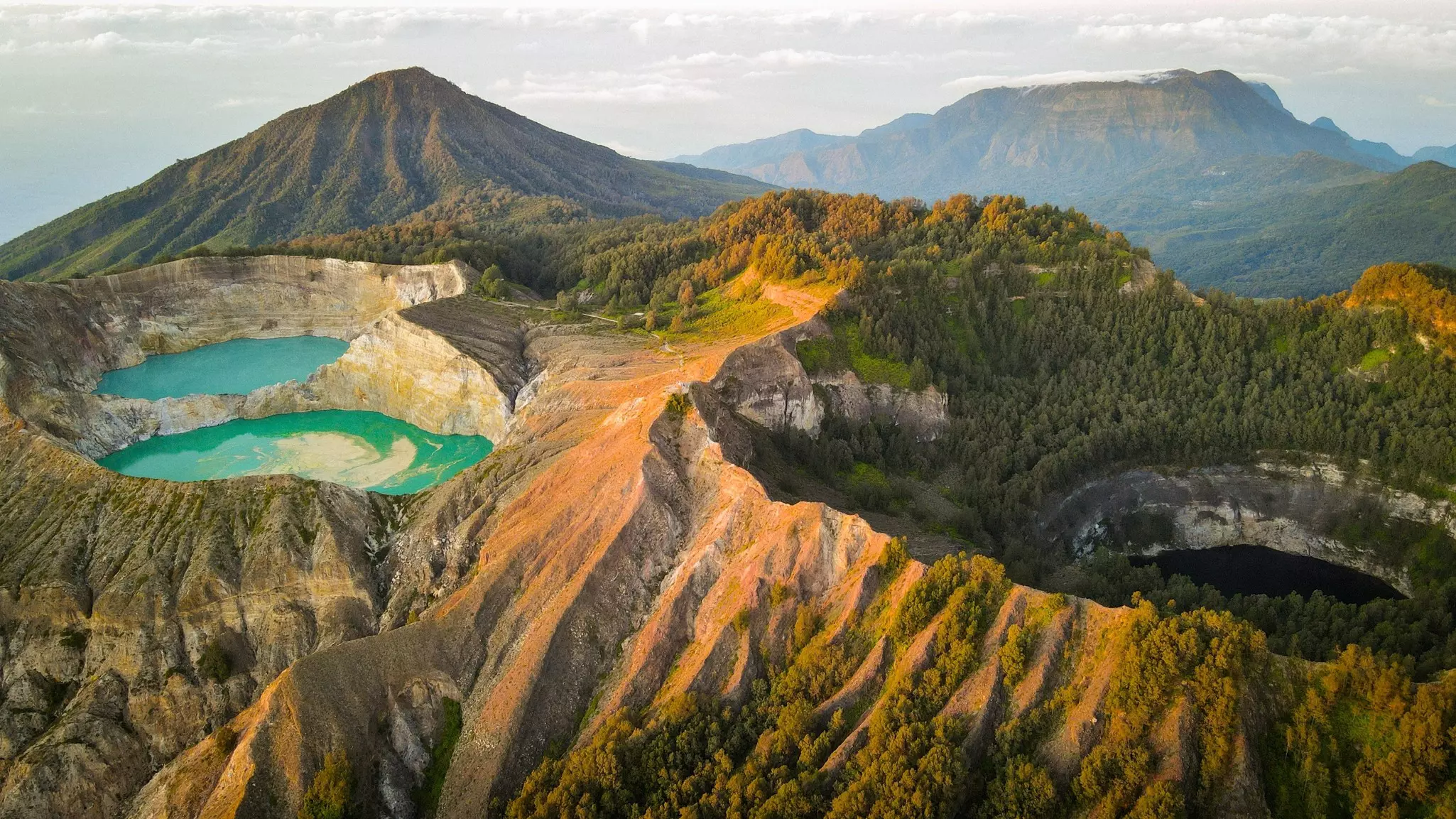 Three crater lakes near the top of a volcano, each with a different shade of green/blue.