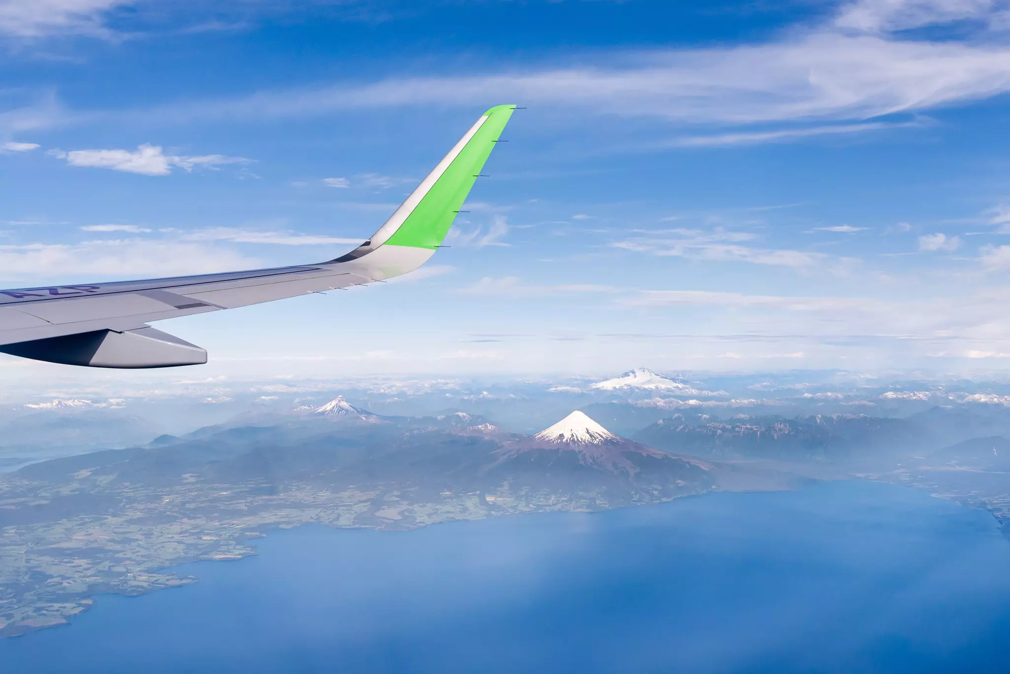 View from of a snowy mountain from an airplane window.