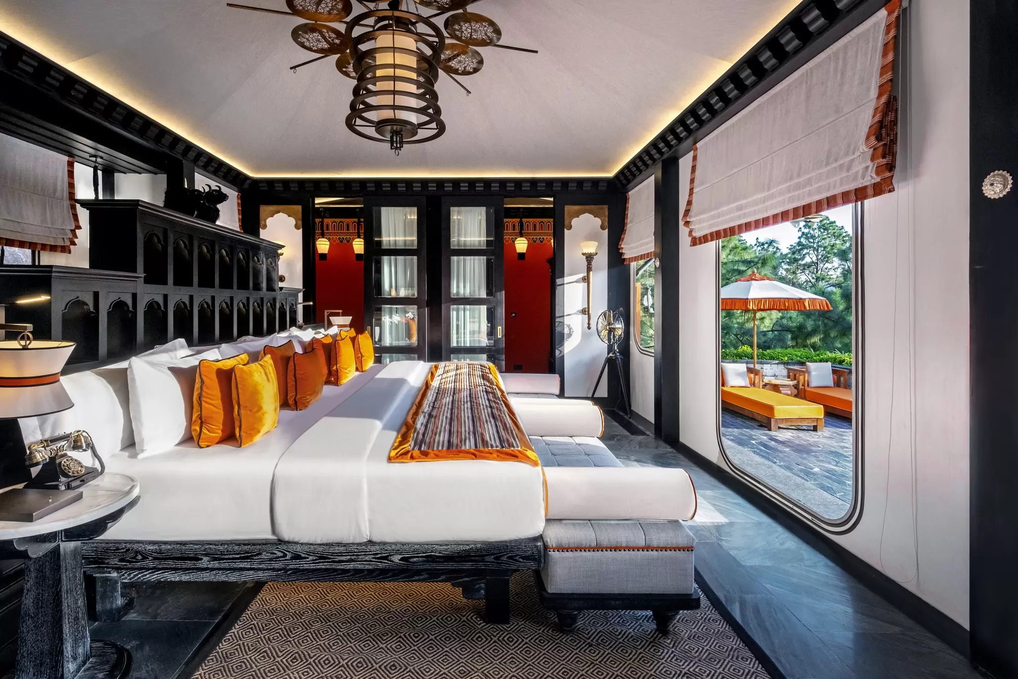A large, black wooden bedframe in a tented villa 