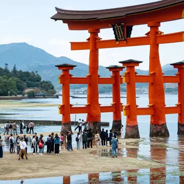 Hiroshima Japan - October 26 2024: tourist at the red Torii Gate at Itsukushima Jinja shinto shrine at low tide outdoor at a beautiful day on a small island in Hiroshima Bay in western of Japan., License Type: media, Download Time: 2025-02-27T18:17:02.000Z, User: rhylton_redventures, Editorial: true, purchase_order: 56530 - Guidebooks, job: Lonely Planet WIP, client: Lonely Planet WIP, other: Rhianydd Hylton