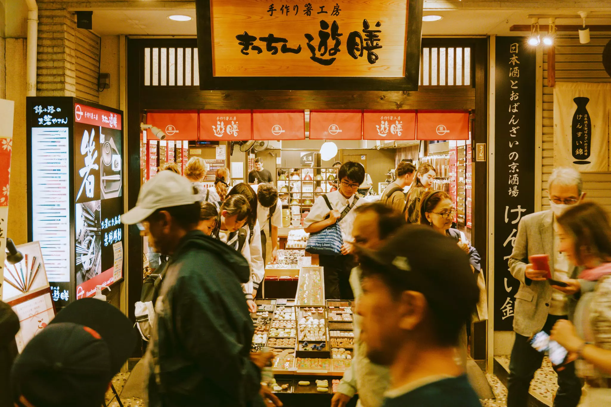 Snacks for sale in Nishiki Market, Kyoto, as shoppers walk by. 