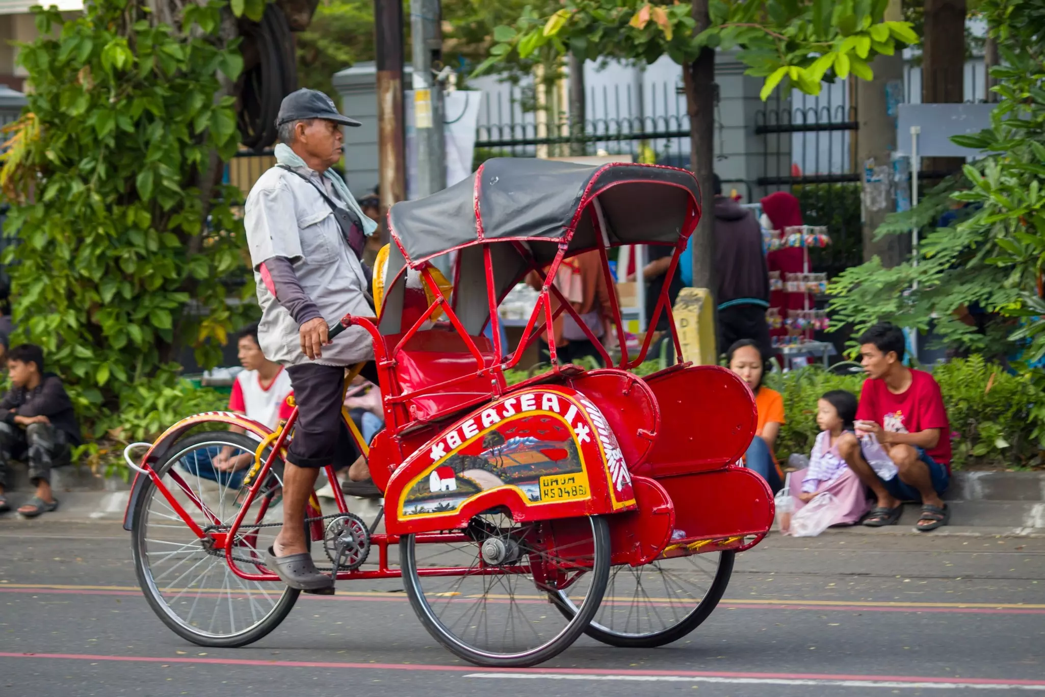 A rickshaw driver looking for passengers in Surakarta, Indonesia.
