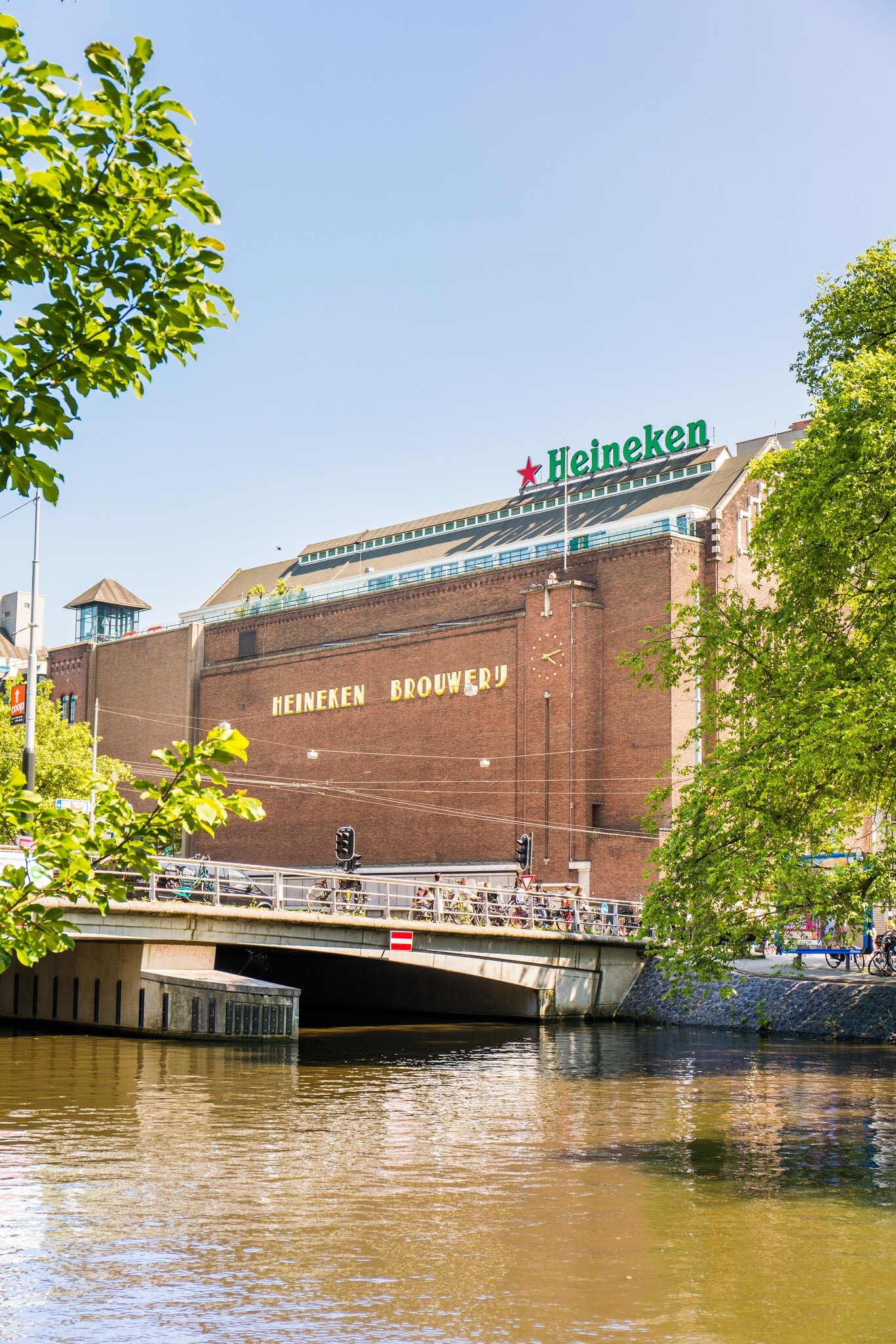 Exterior view of the building housing the Heineken Experience on a sunny day in Amsterdam.