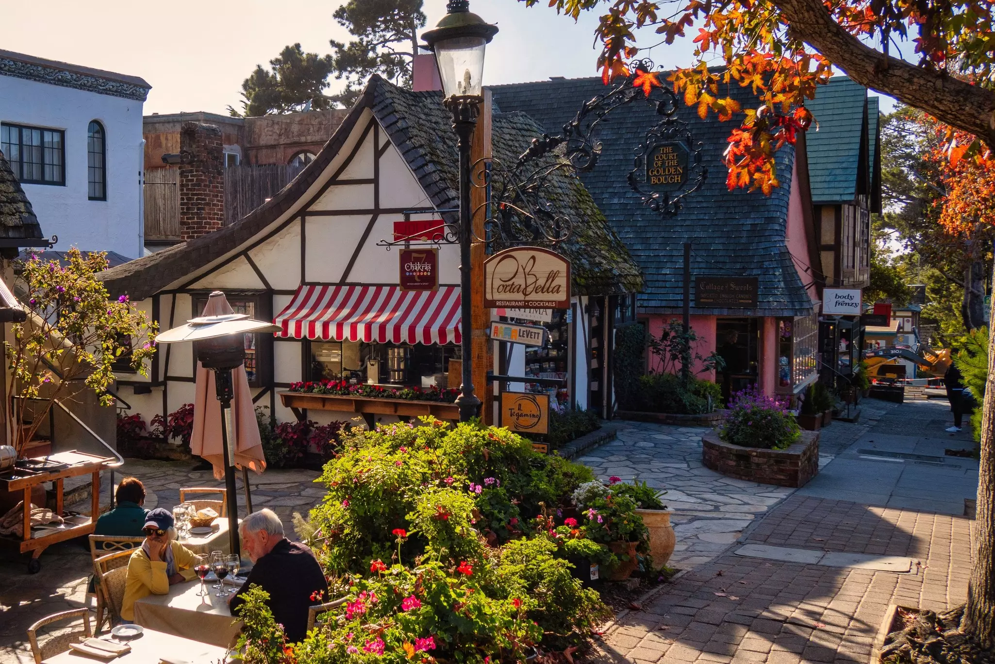People sit at a table on a terrace in late afternoon in a California town.