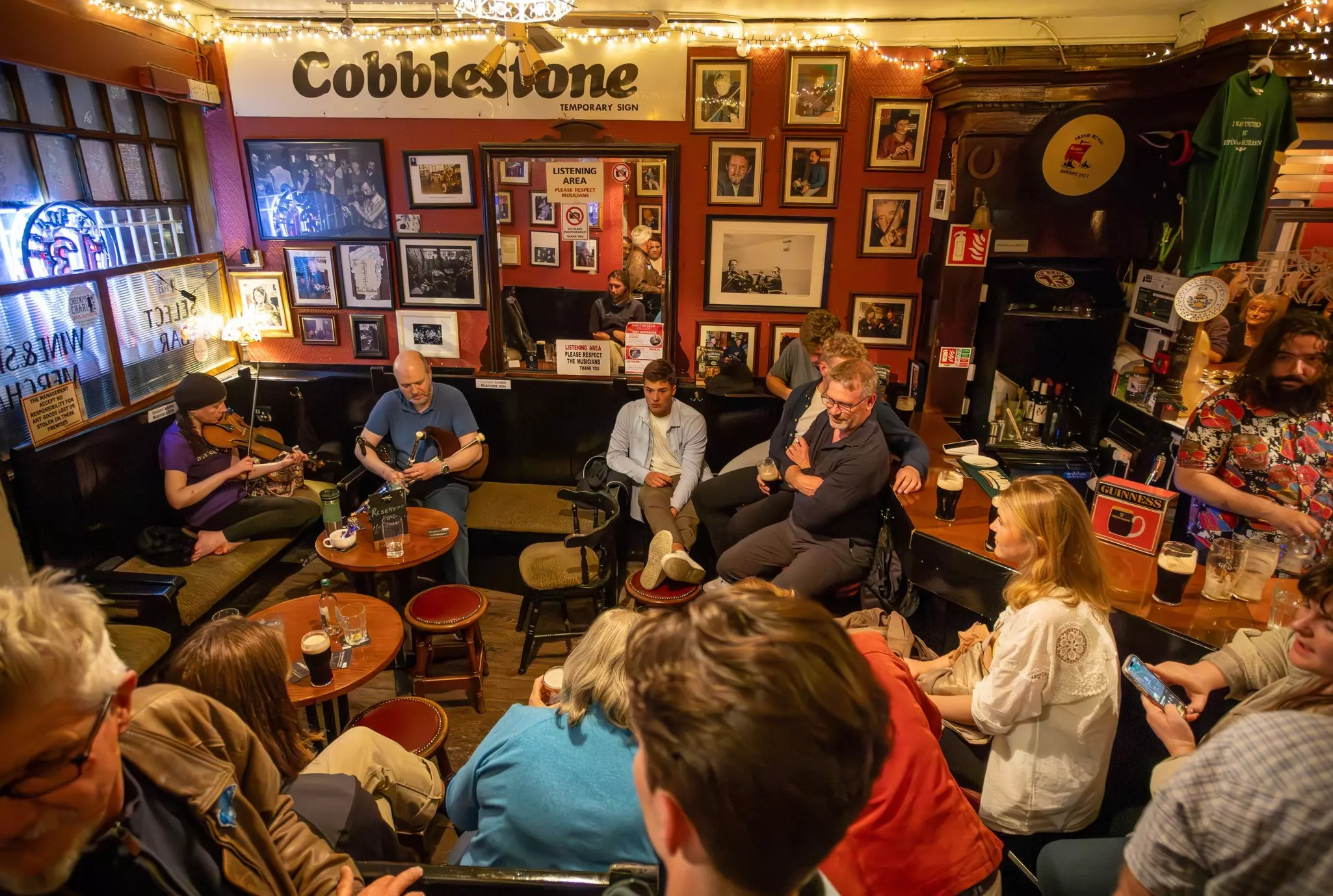 Two folk musicians play violin and bagpipes for visitors in Cobblestone, a pub famous for its traditional Irish music and a cornerstone of Dublin's music scene