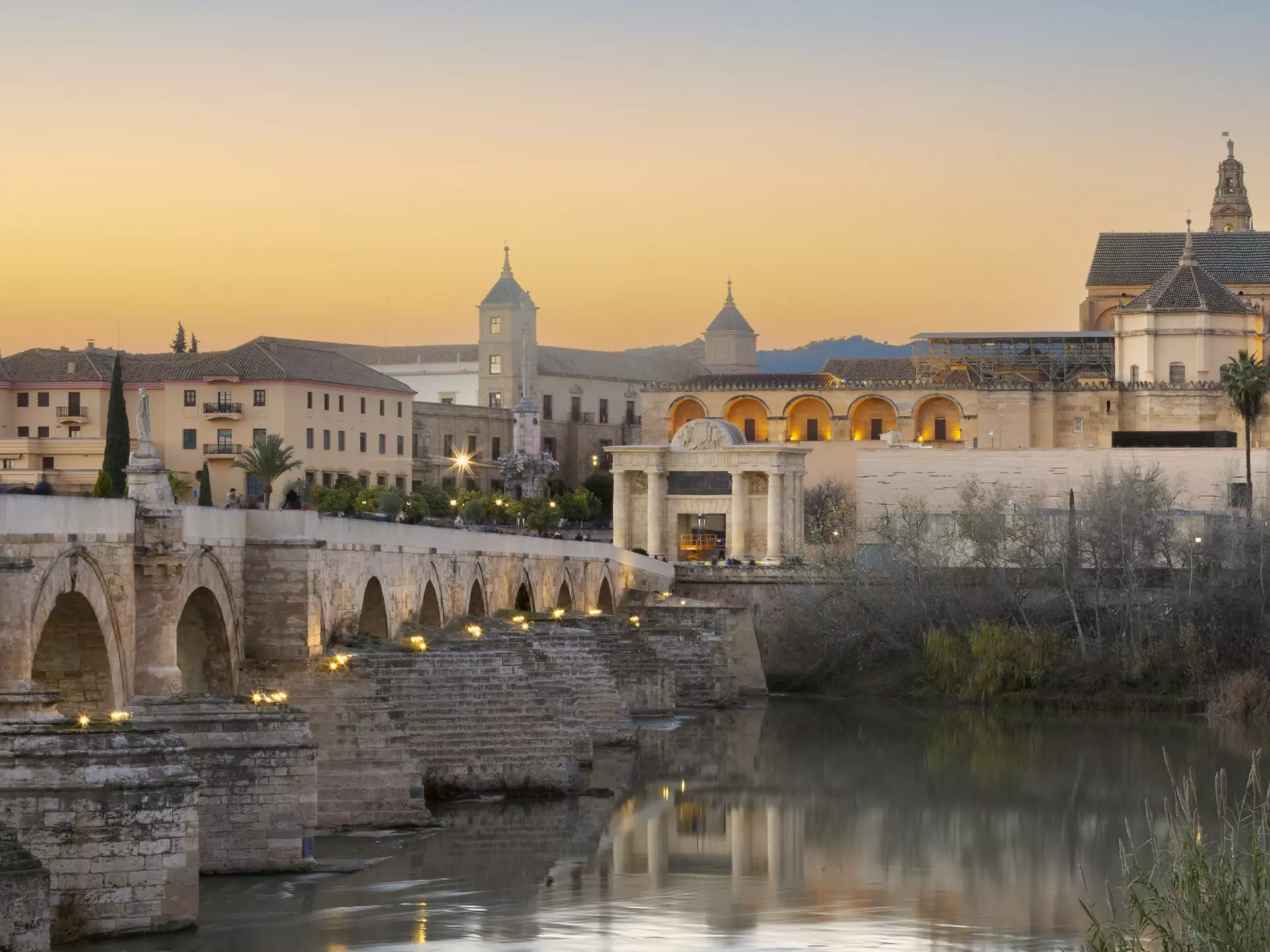 A Roman bridge over the Guadalquivir river in Córdoba Spain, with the Great Mosque in the distance © istock / Getty Images