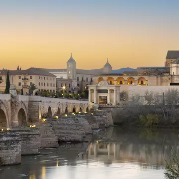 A Roman bridge over the Guadalquivir river in Córdoba Spain, with the Great Mosque in the distance © istock / Getty Images