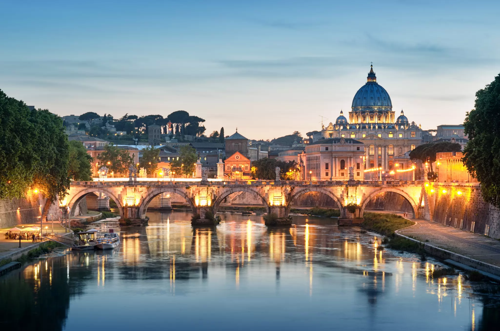 Night image of River Tiber, including: Ponte Sant Angelo and St. Peter's Basilica in the background. Rome - Italy.
