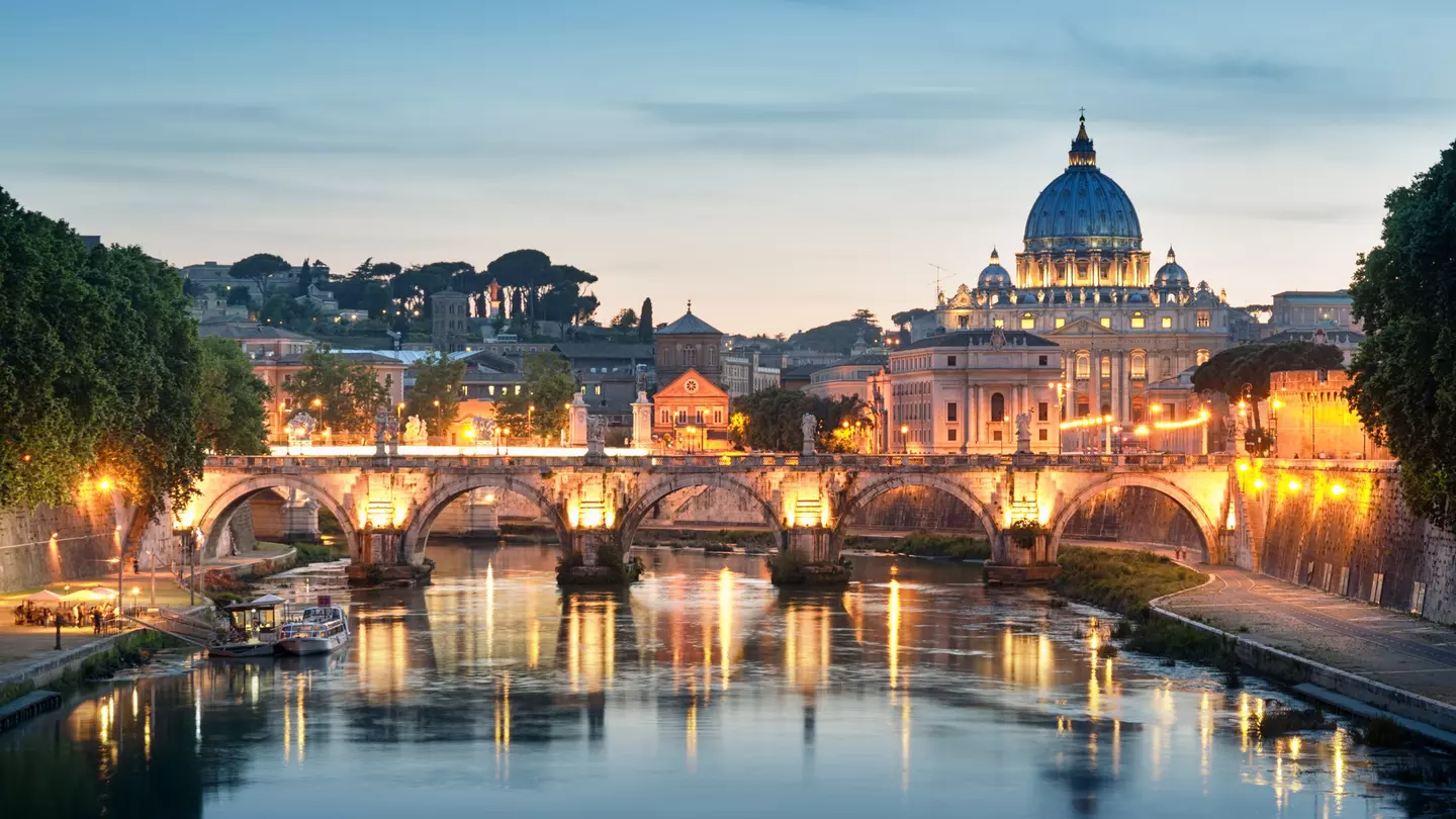 Night image of River Tiber, including: Ponte Sant Angelo and St. Peter's Basilica in the background. Rome - Italy.