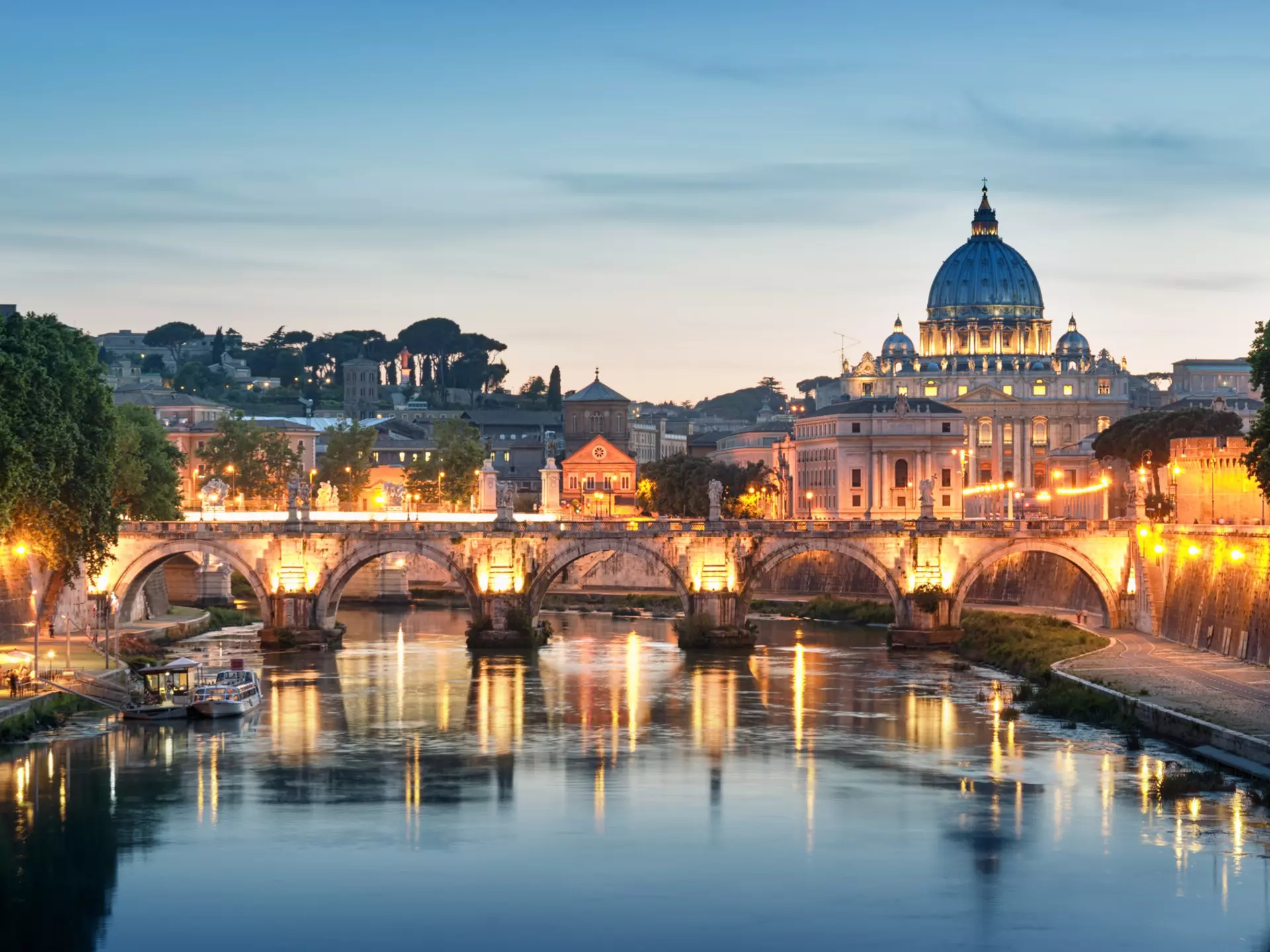Night image of River Tiber, including: Ponte Sant Angelo and St. Peter's Basilica in the background. Rome - Italy.