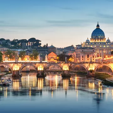 Night image of River Tiber, including: Ponte Sant Angelo and St. Peter's Basilica in the background. Rome - Italy.
