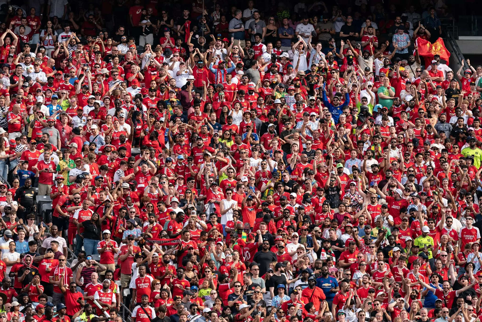 Fans of Arsenal FC and of Manchester United attend a friendly game.
