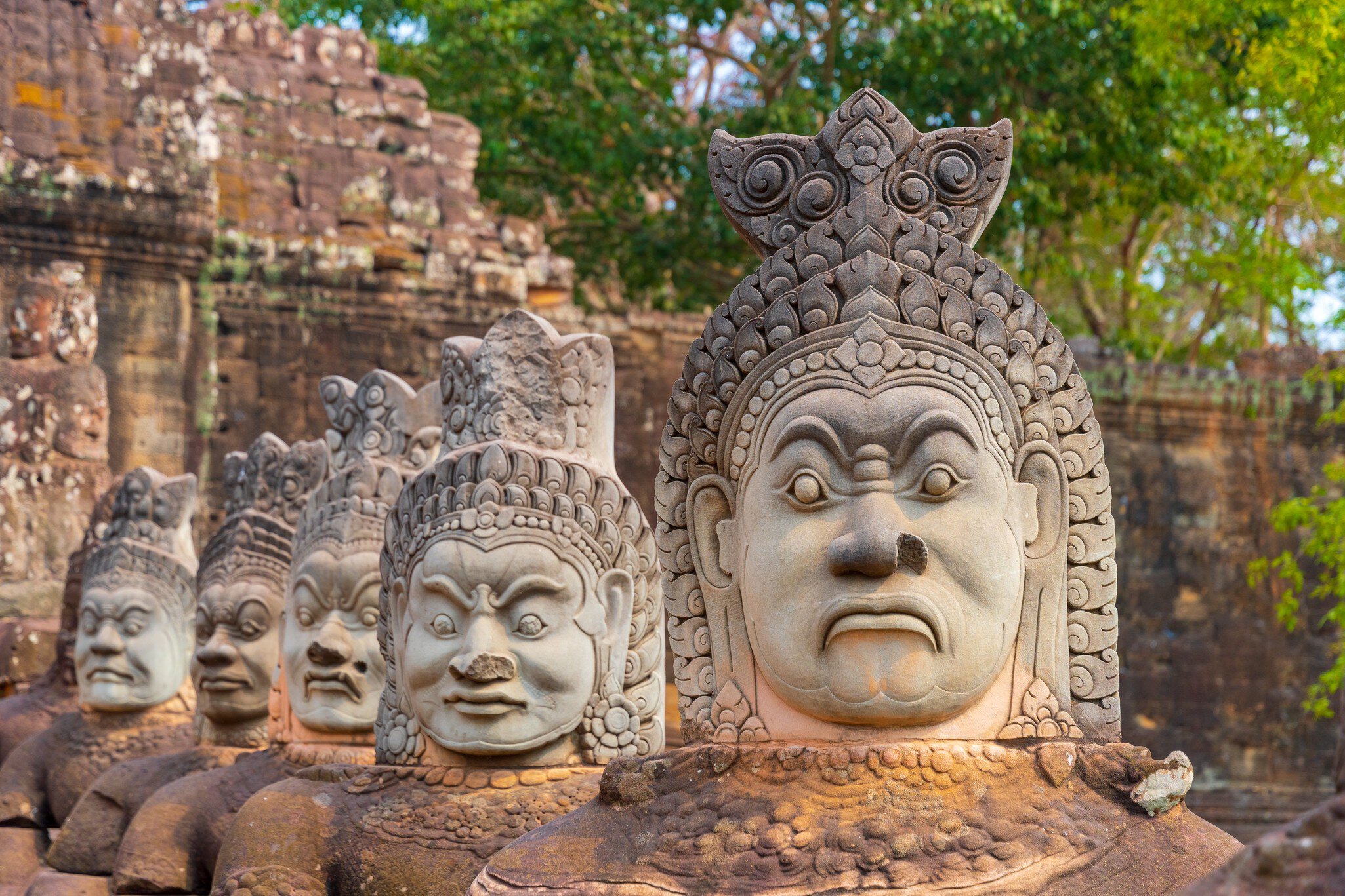 Ancient Hindu statues along sides of the south bridge into Angkor Thom temple close to Angkor Wat and Siem Reap in Cambodia
