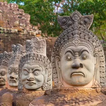 Ancient Hindu statues along sides of the south bridge into Angkor Thom temple close to Angkor Wat and Siem Reap in Cambodia