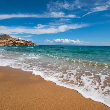 View of waves washing onto Paradise Beach on the island of Mykonos in Greece.