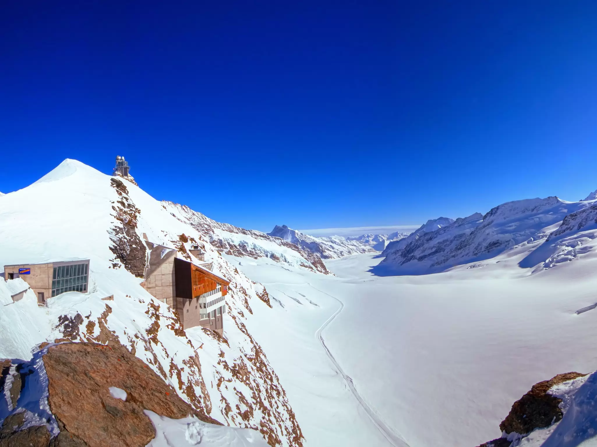 A view of the Jungfraujoch station and the Jungfraufirn glacier, part of the Jungfrau-Aletsch Unesco World Heritage Site. The station building is built into the side of the cliff face.
