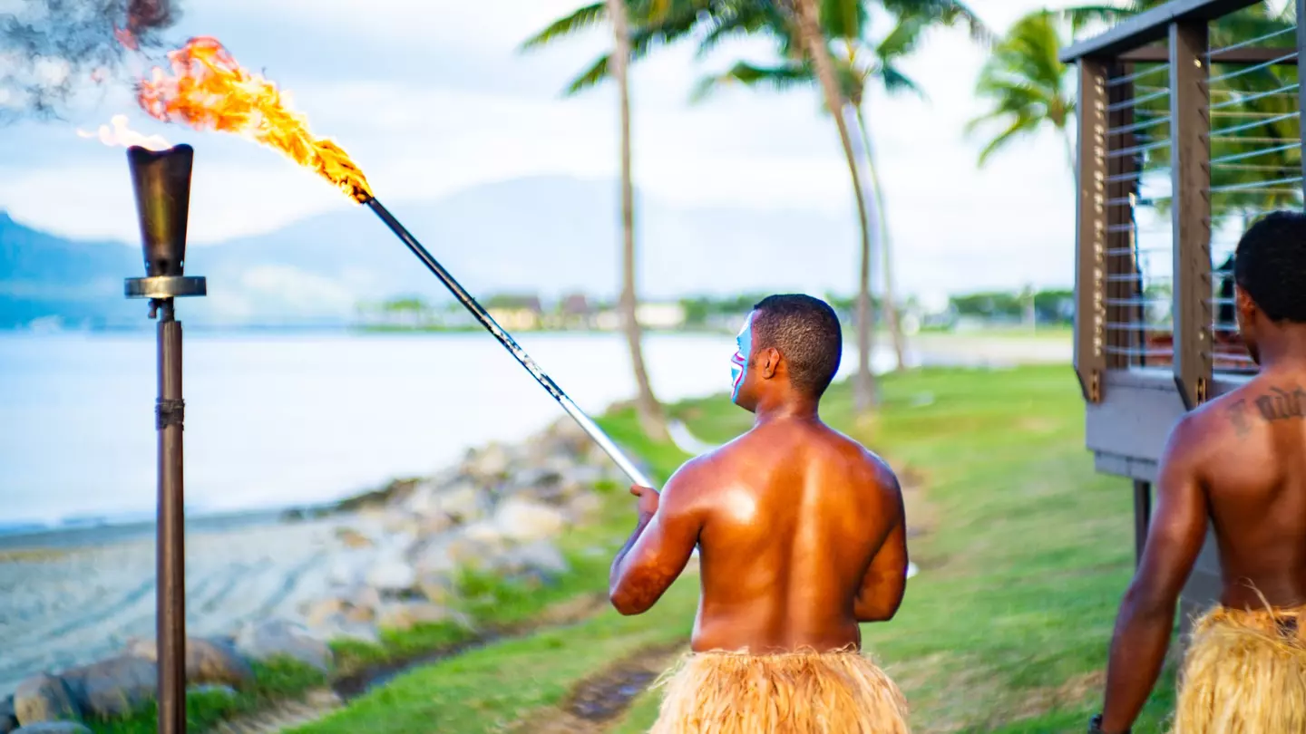 Fijian people performing the lighting of the beach torches.