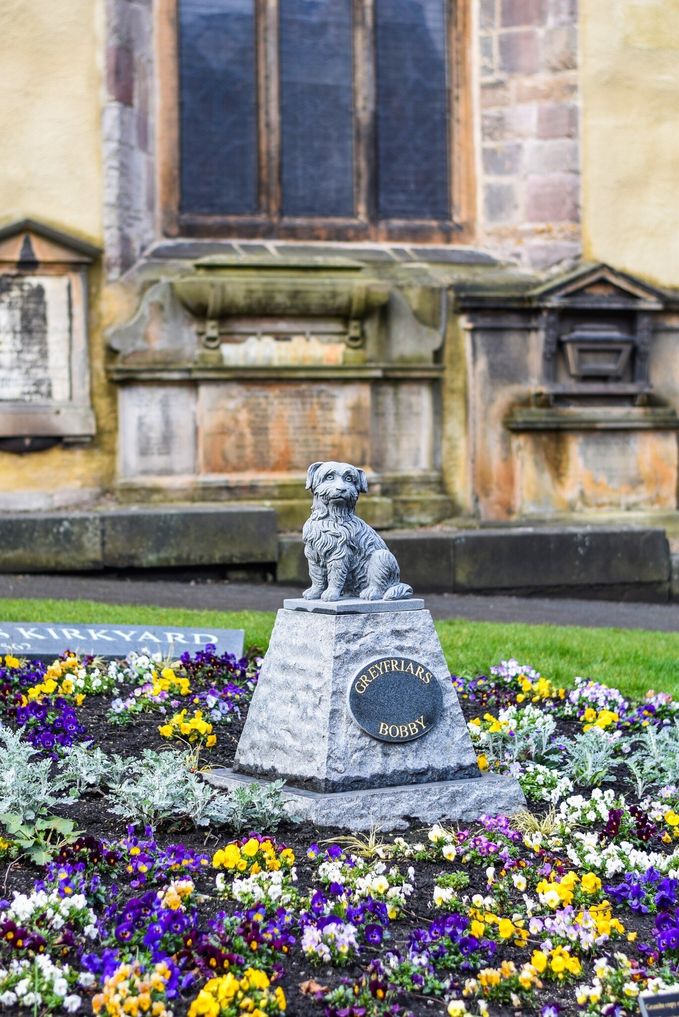 The Greyfriars Bobby grave at Greyfriars Kirkyard, honoring the dog that stayed with his master after death in Edinburgh, Scotland.