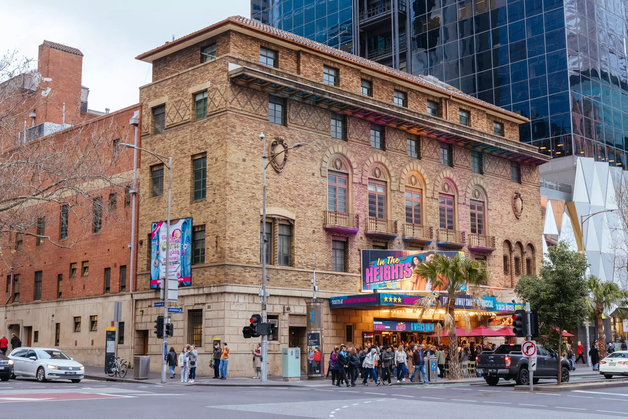 People queue outside Melbourne's famous Comedy Theatre illuminated with signage for In The Heights musical