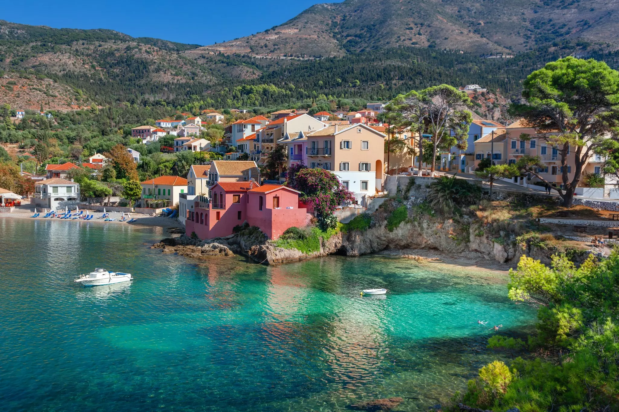 A bay with turquoise waters overlooked by colorful houses