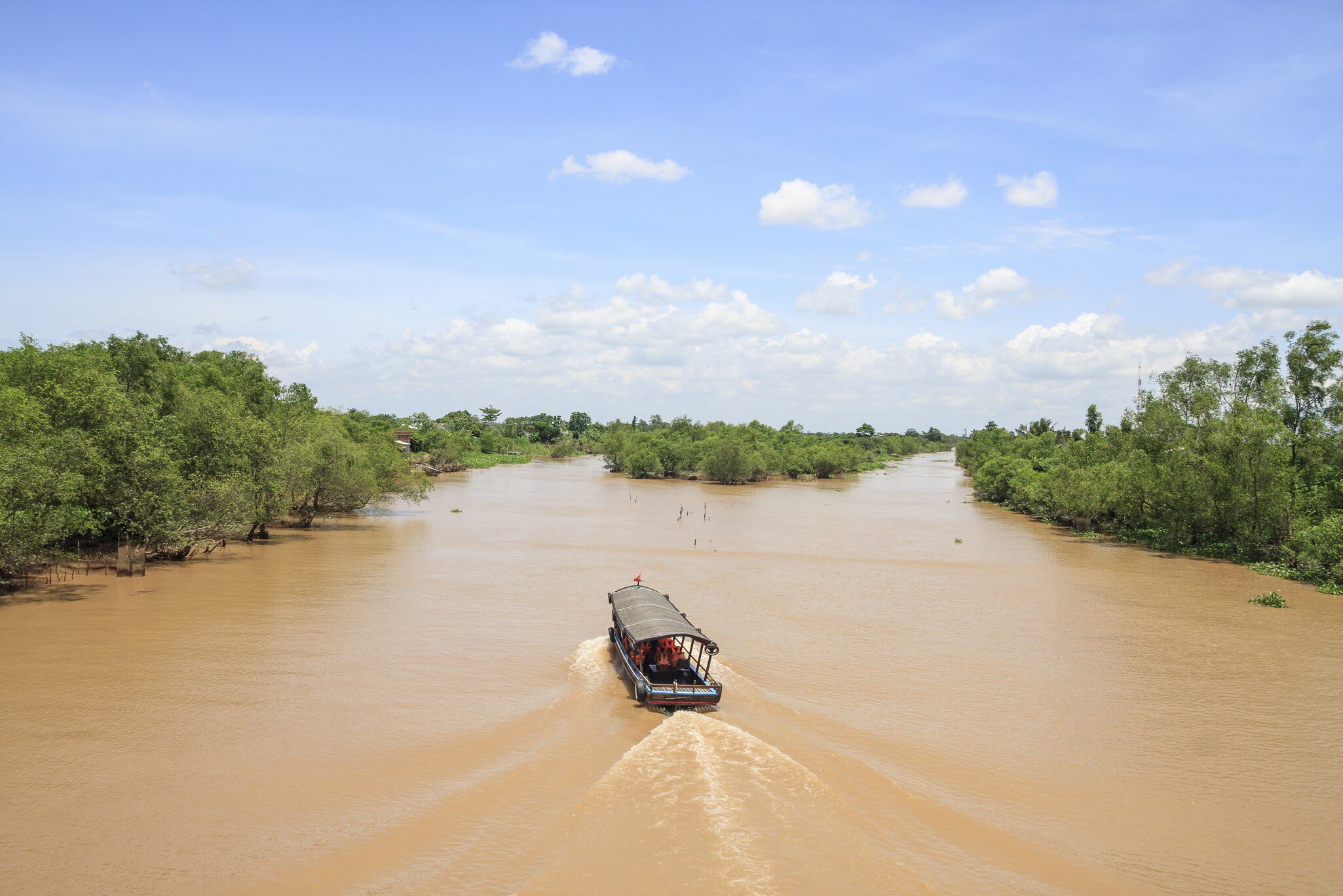 Aerial scene of a boat passing through An Binh island in Vinh Long, Vietnam.