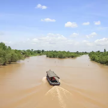Aerial scene of a boat passing through An Binh island in Vinh Long, Vietnam.