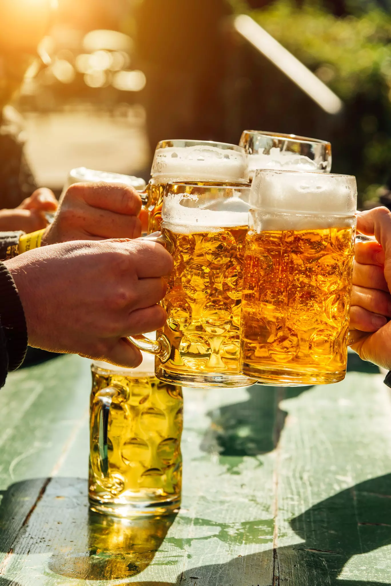 People clink their mugs of beer at Oktoberfest in Munich, Germany. 