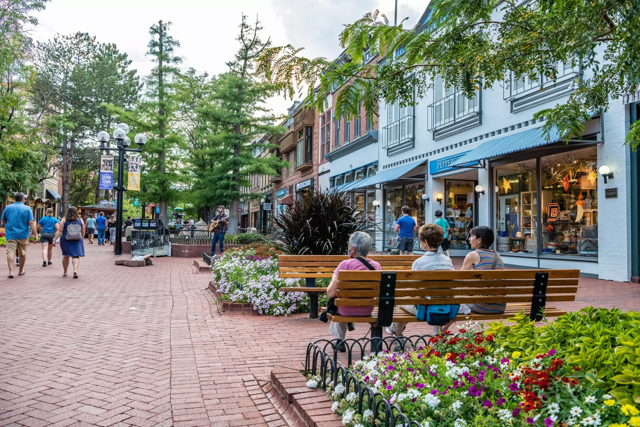Women friends sit together on Pearl Street Mall, Boulder.
