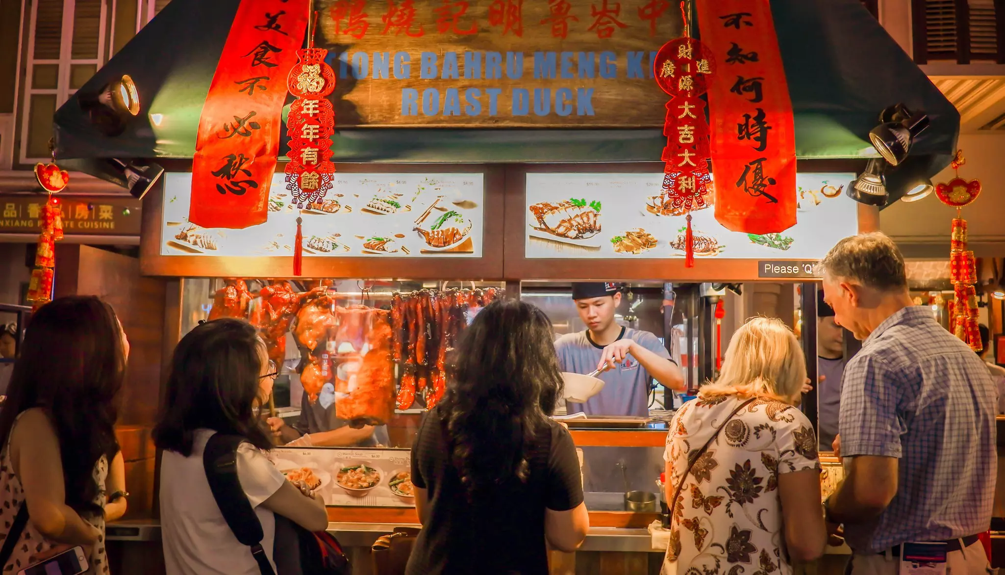 Image of crowded people in front of traditional noodle shop in Chinatown, Singapore. Traditional Chinese street, market, road with shop-houses.