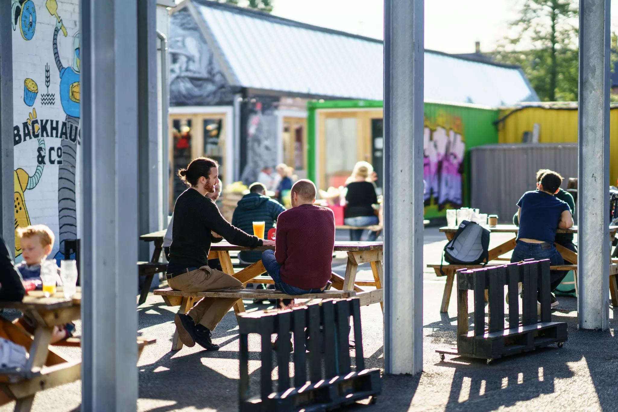 People having a drink a warm day in Coventry's FarGo Village, England.