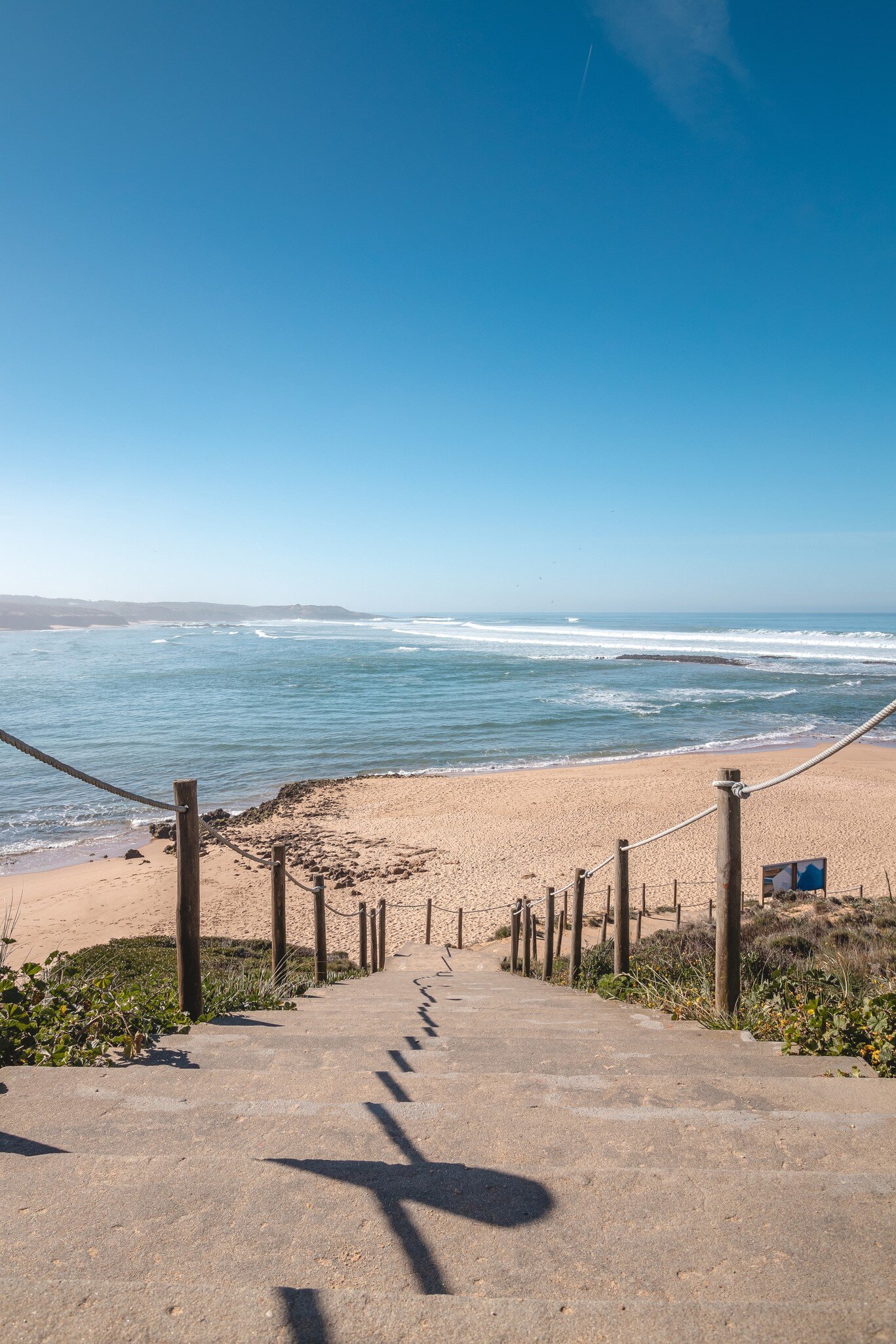 Wooden steps leading down to Praia do Farol near Vila Nova de Milfontes, as part of the Rota Vicentina, in Portugal.
