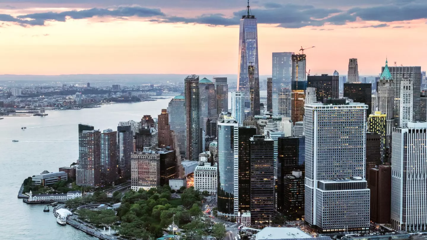 Aerial view of a city with glass-and-steel skyscrapers on the edge of a river
