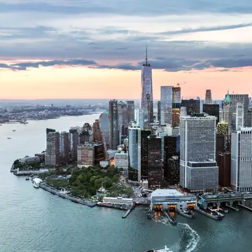 Aerial view of a city with glass-and-steel skyscrapers on the edge of a river
