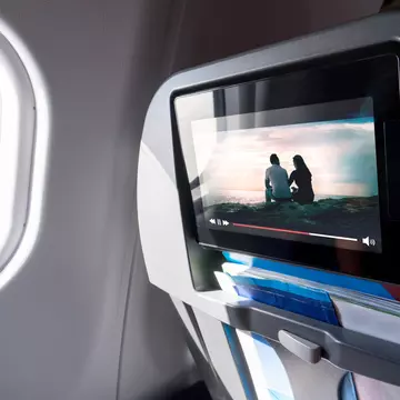 Watching movie on an airplane touch screen. Imaginary film playing on a video player in monitor during long flight. Entertainment service system in aircraft.