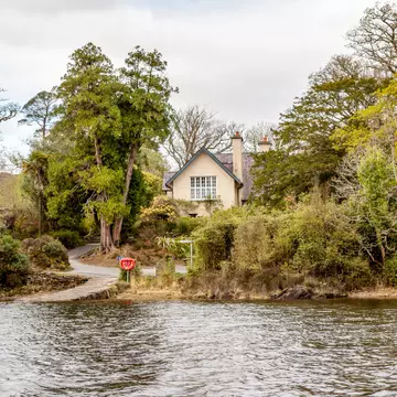 Exterior of Dinis Cottage with trees surrounding, Killarney National Park, County Kerry, Ireland.