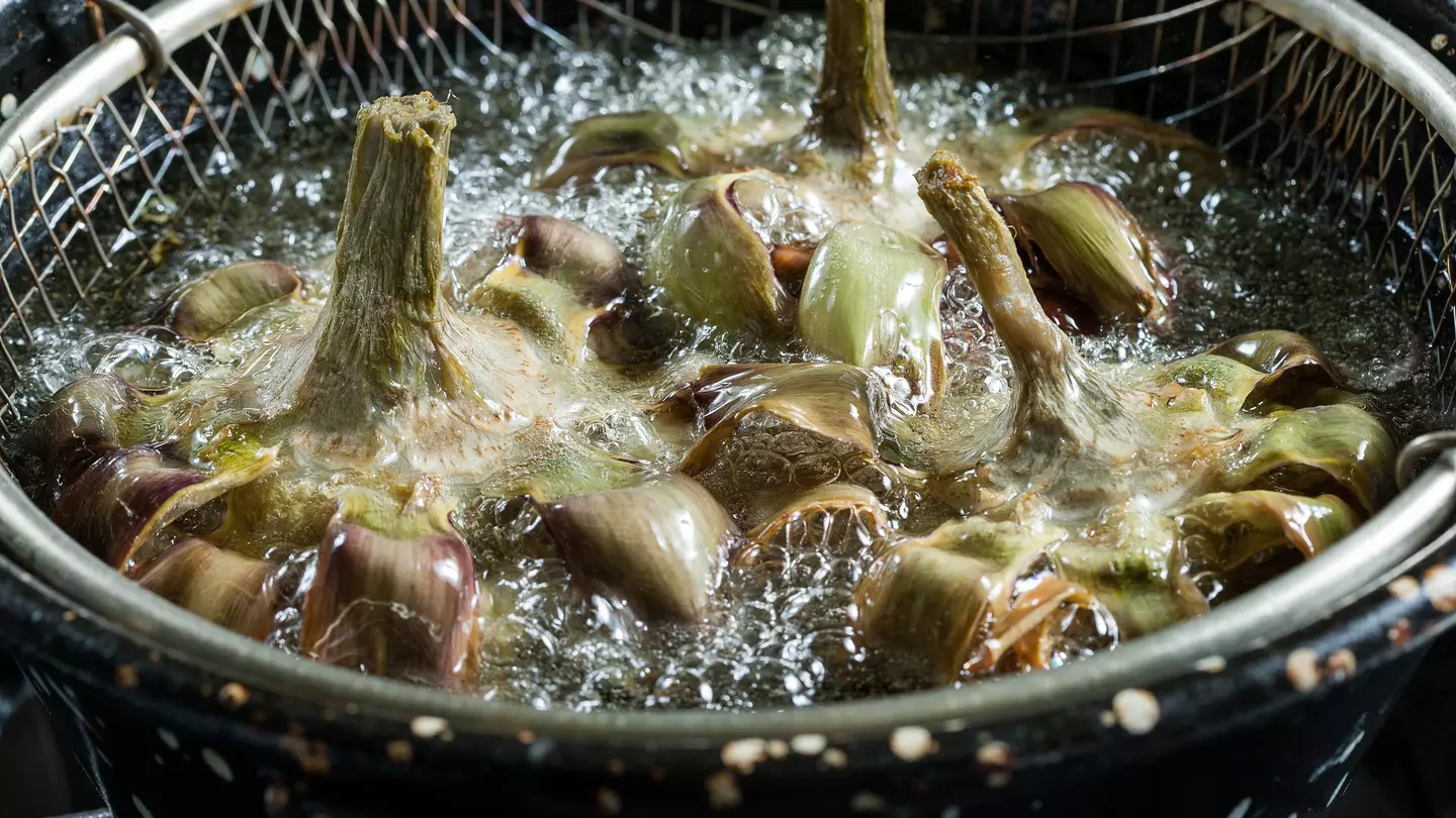 Close-up of frying artichokes in a pot of hot oil