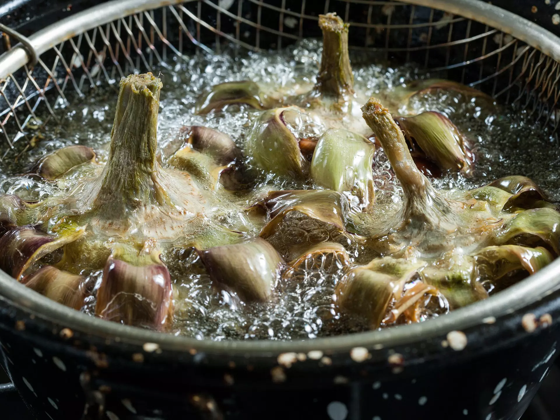 Close-up of frying artichokes in a pot of hot oil