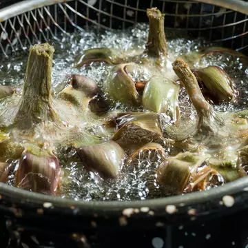 Close-up of frying artichokes in a pot of hot oil